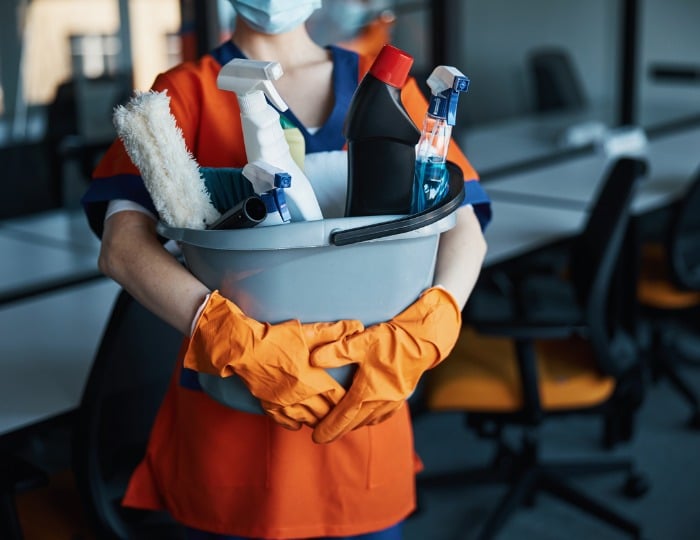janitorial tech holding cleaning supplies
